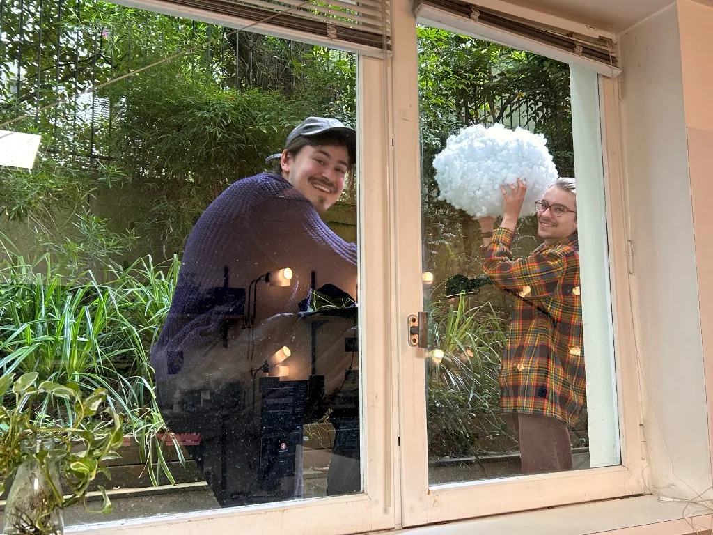 Two collaborators carrying an early cloud prototype through a garden