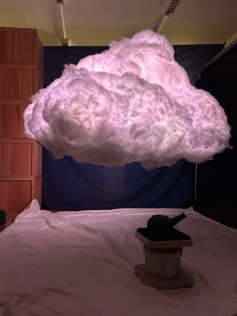 The completed illuminated cloud suspended above a seat in the exhibition installation